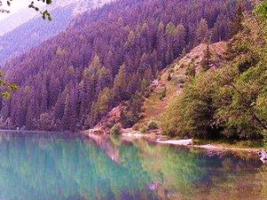image of lake with tree covered mountains in the background