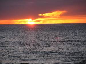 image of sun setting over water